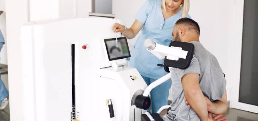 Paciente y fisioterapeuta usando tecnología en fisioterapia.